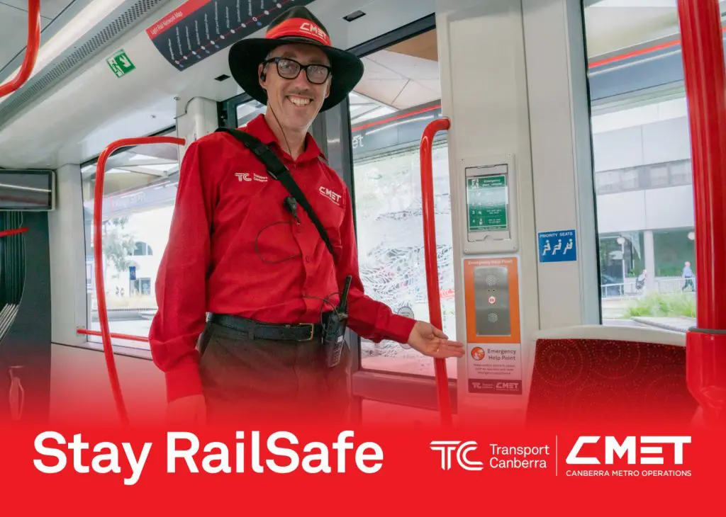 Staff pointing out the Emergency Help Point at light rail