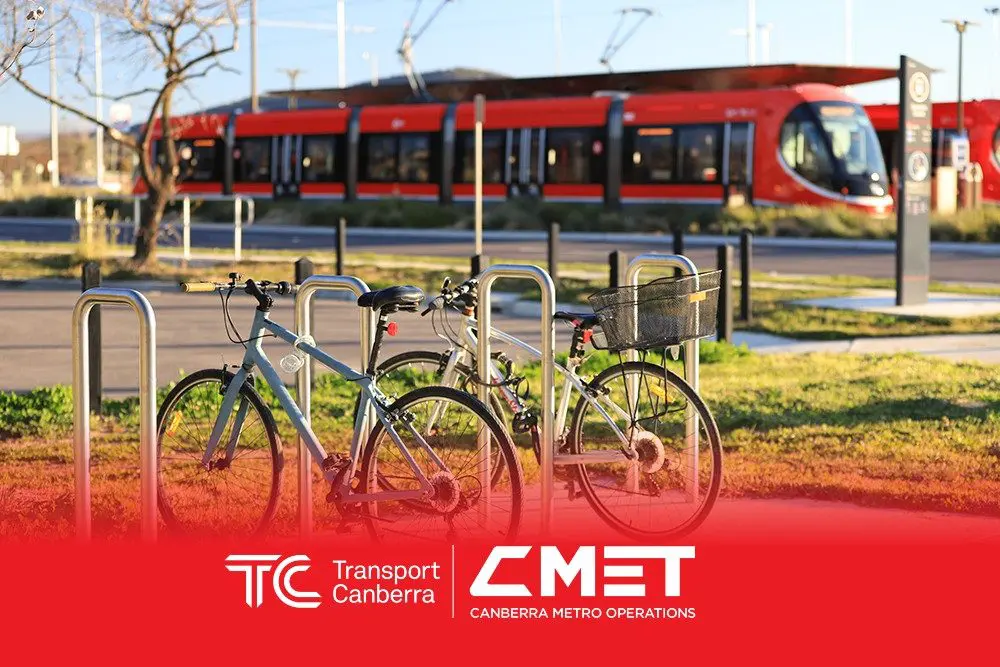 Bikes stoping at the racks next to a light rail stop
